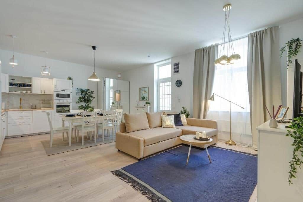 A modern living room with a sofa, coffee table, and dining area.