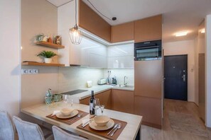 Eine moderne Küche mit Essbereich, ausgestattet mit Herd, Spüle und integriertem Backofen.