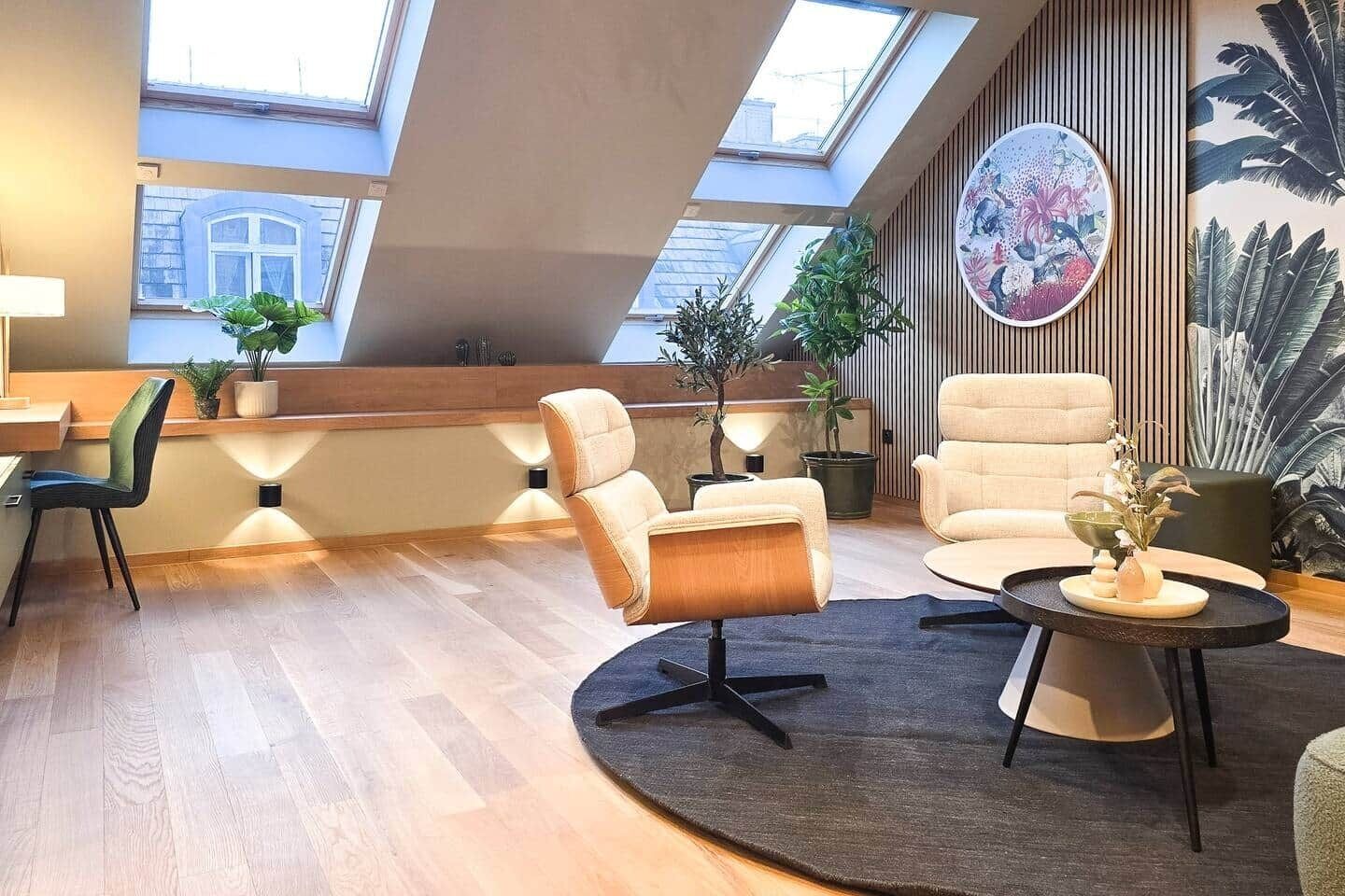 Un saló modern d'estil loft amb finestres de sostre, una taula de cafè rodona i una planta gran.