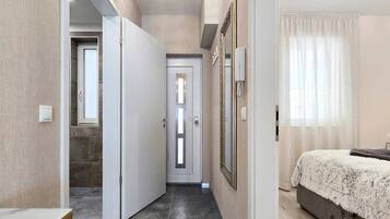 A bedroom with a bed, a door, and a mirror.