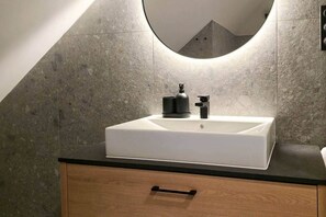 A bathroom with a white sink, black faucet, and a single drawer below. - IMCT - Urban Jungle Apartments 10 (Budapest)