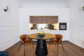 Eine moderne Küche mit weißen Schränken, einer Holz Arbeitsplatte und einem eingebauten Backofen.