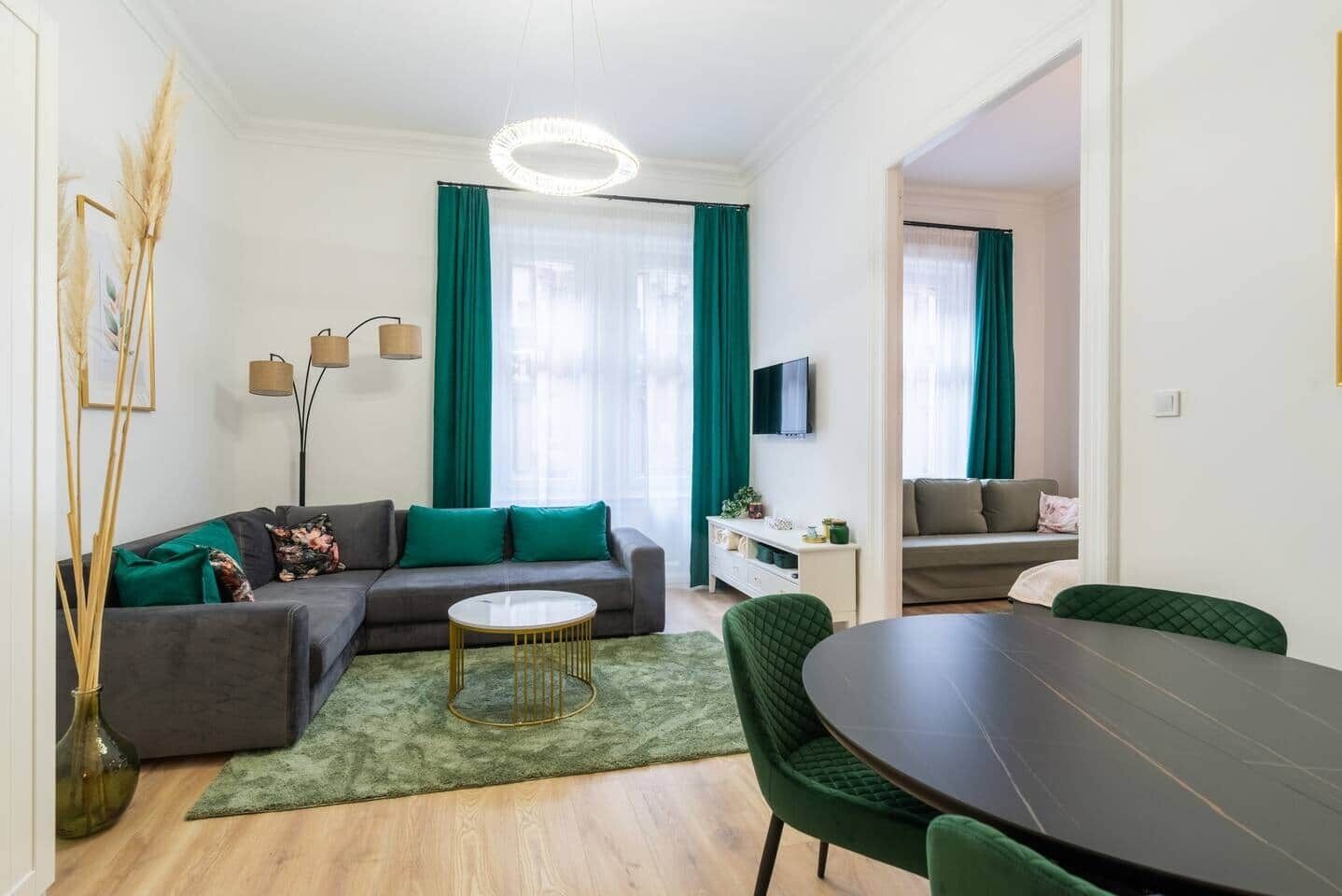 Un salon moderne avec un canapé, une table basse ronde et une table à manger avec des chaises.