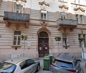 A building with a classic architectural style, featuring ornate balconies and a central entrance with a decorative arch. - IMCT - Rose Apartment (Budapest)