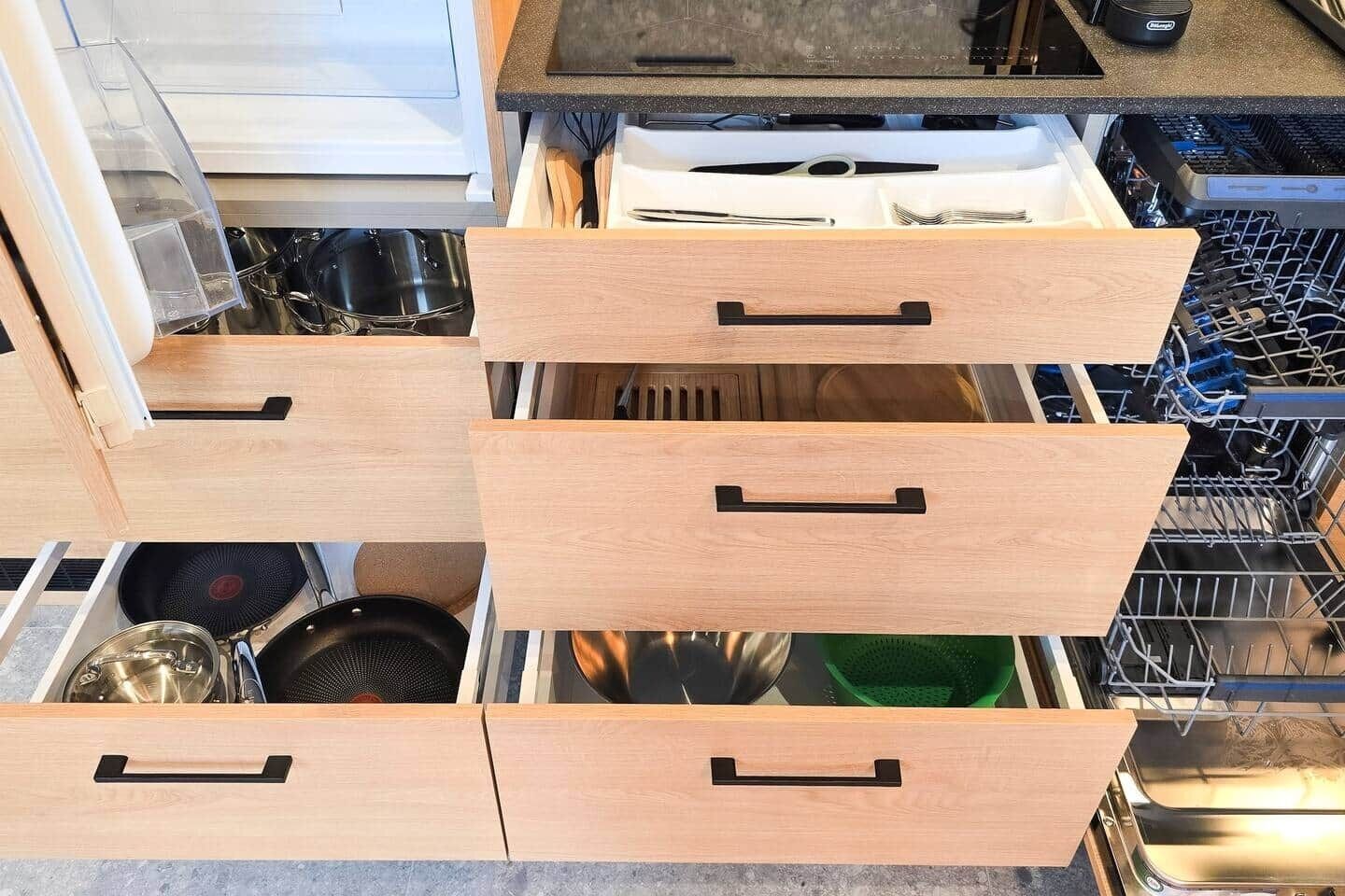 A kitchen with wooden drawers and a dishwasher.