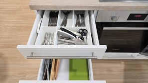 A kitchen drawer with utensils and a Bosch oven in the background. - IMCT - Central Vibe Apartments 3 (Budapest)