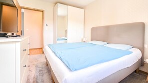 Ein Schlafzimmer mit einem Bett, einem Schminktisch und einem Spiegel.
