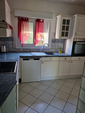 Una cocina con lavavajillas integrado, un lavabo y una estufa.