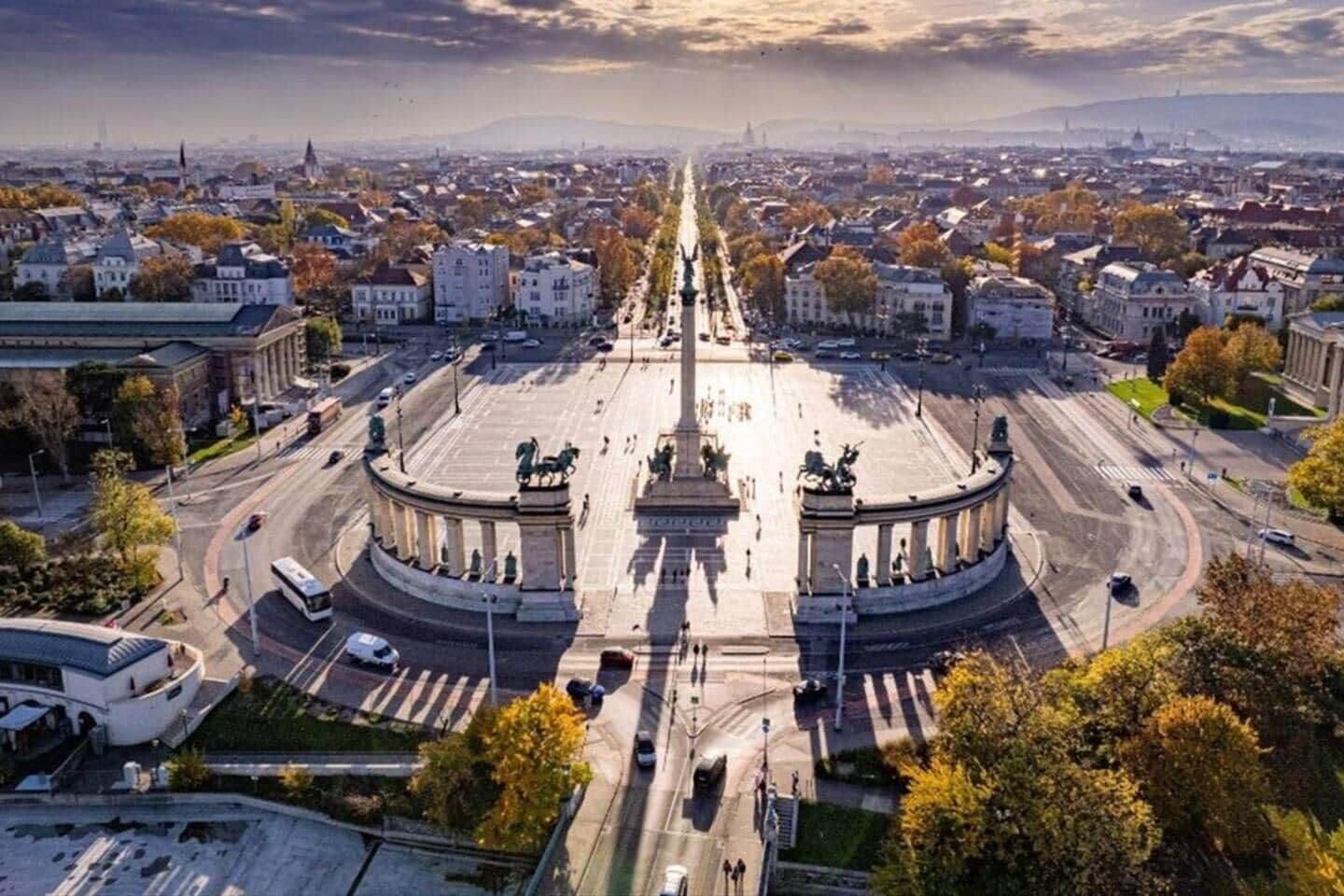 Una amplia plaza abierta con un monumento central, rodeada de edificios y calles.