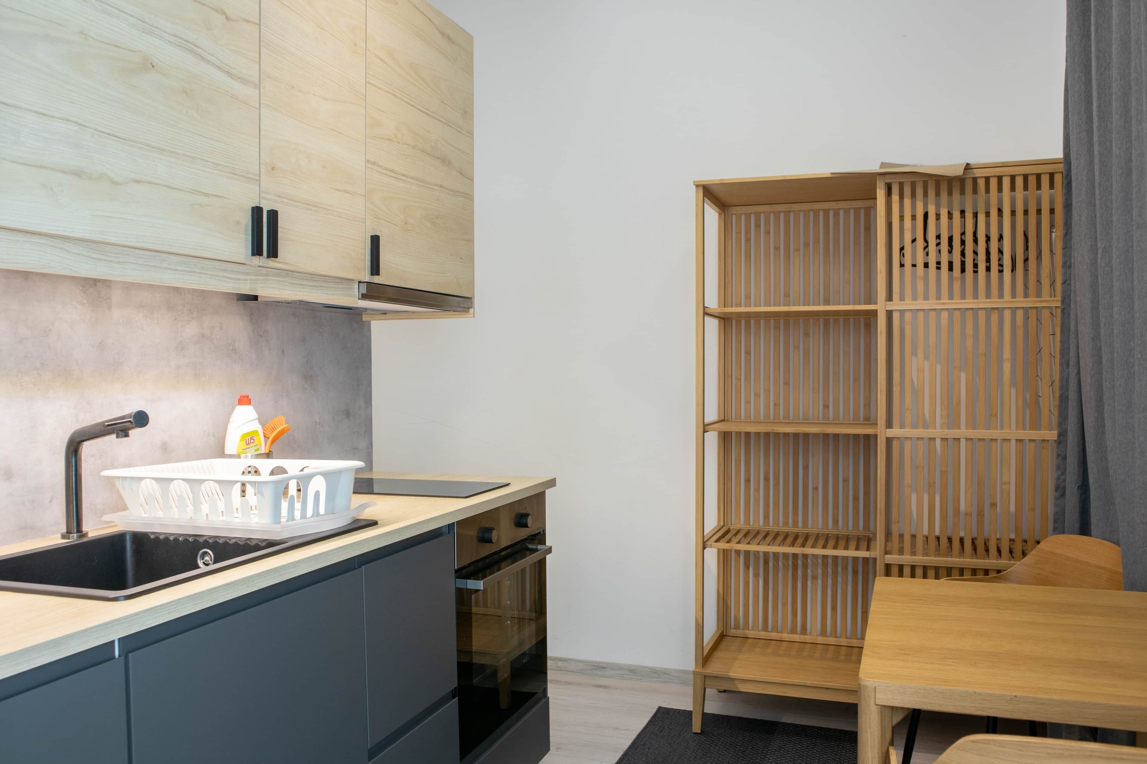 A compact kitchen with a sink, stove, and wooden cabinets.