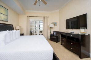 A hotel room with a large bed, a desk with drawers, a chair, a television, and a window with curtains. - The Oasis 1604 Formerly Phoenix West Ii 1604 3 Bedroom Condo (Orange Beach)