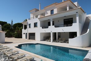 A two-story building with a swimming pool, outdoor seating, and a staircase leading to the upper floor. - Villa Irene 7 Bed Villa close to Marina (Vilamoura)