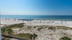 A beach with a wooden walkway leading to the shore, sandy beach, and umbrellas. - The Oasis 503 Formerly Phoenix West Ii 503 3 Bedroom Condo (Orange Beach)