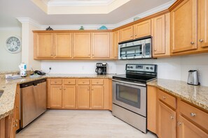 Eine Küche mit Holzausstattung, einer Mikrowelle, einer Kaffeemaschine und einem Backofen.