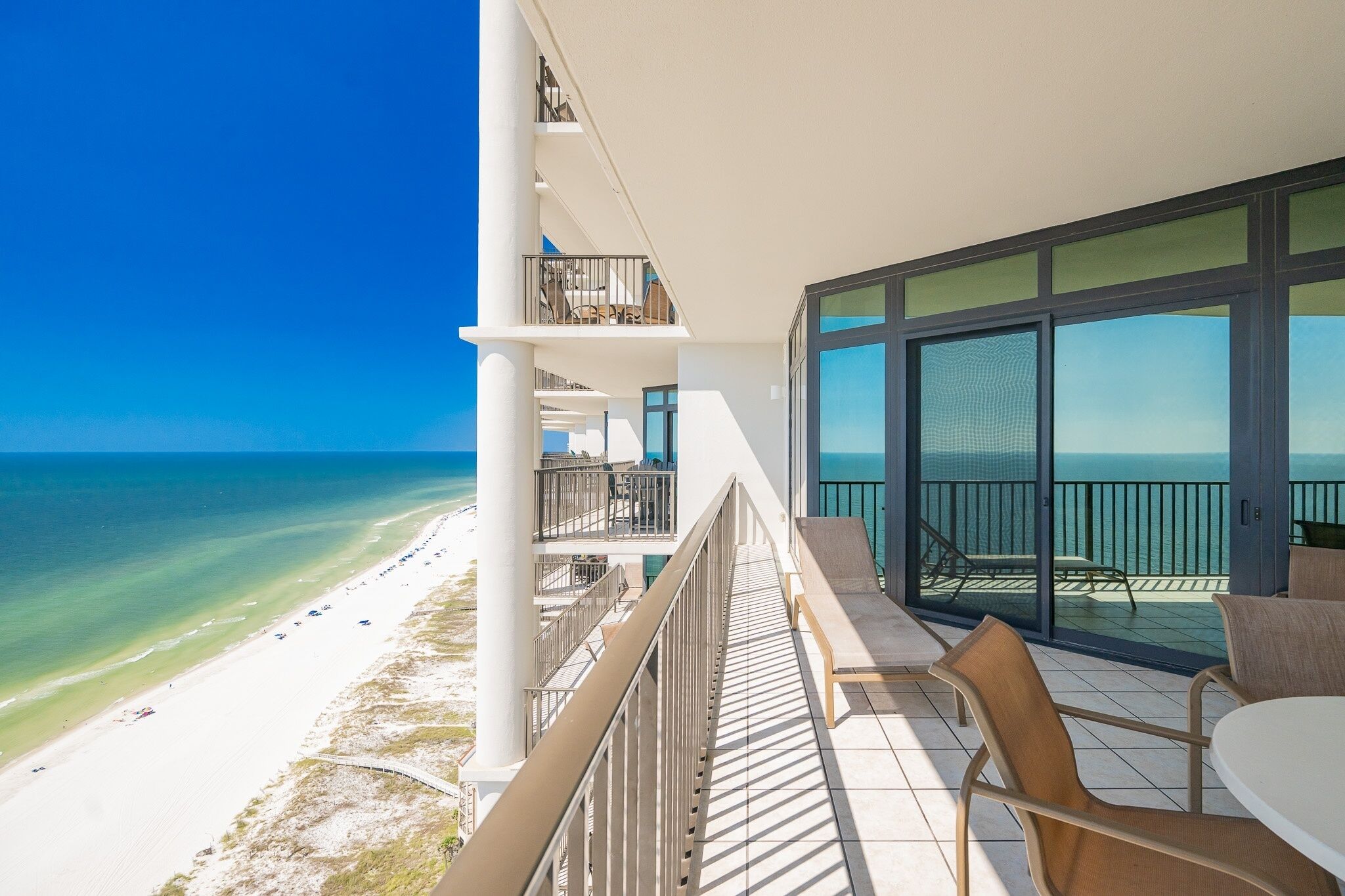 A balcony with a view of the beach and ocean.