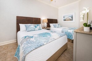 A hotel room with two beds, a nightstand with a lamp, a framed picture on the wall, and a potted plant. - The Oasis 904 Formerly Phoenix West Ii 904 3 Bedroom Condo (Orange Beach)