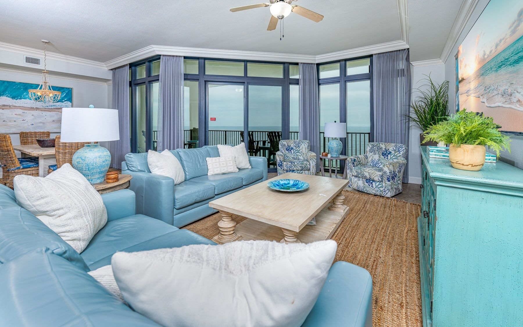 A modern living room with a blue sofa, a coffee table, and a large window with curtains.