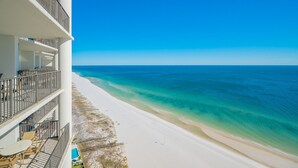 Un hotel fronte mare con piscina, balconi e vista diretta sull'oceano.