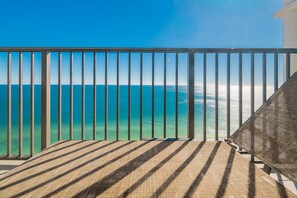 A balcony with a view of the ocean, a wooden deck, and a metal railing. - The Oasis 2405 Formerly Phoenix West Ii 2405 3 Bedroom Condo (Orange Beach)