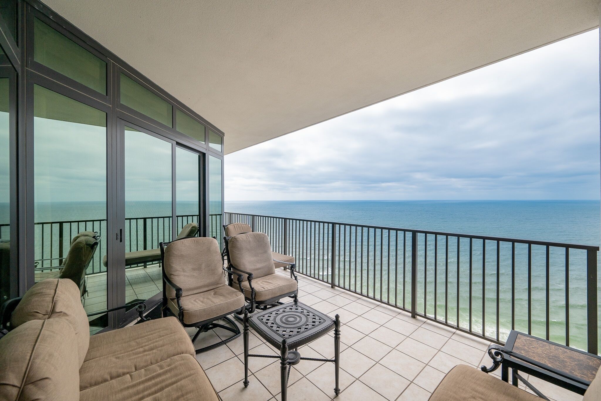 Ein Balkon mit Meerblick, möbliert mit Stühlen und einem Tisch.