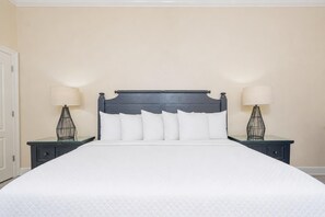 A hotel room with a large bed, two bedside tables with lamps, and a plain wall. - The Oasis 2609 Formerly Phoenix West Ii 2609 3 Bedroom Condo (Orange Beach)
