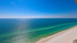 A beach with clear turquoise waters and a sandy shore. - The Oasis 3208 Formerly Phoenix West Ii 3208 3 Bedroom Condo (Orange Beach)