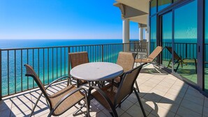 A balcony with a round table and chairs, overlooking a clear blue sea. - The Oasis 3208 Formerly Phoenix West Ii 3208 3 Bedroom Condo (Orange Beach)