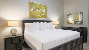 A modern bedroom with a large bed, two bedside tables, and a wall-mounted mirror. - The Oasis 3208 Formerly Phoenix West Ii 3208 3 Bedroom Condo (Orange Beach)