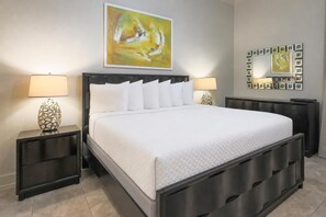 Ein modernes Schlafzimmer mit einem großen Bett, zwei Nachttischen und einem wandmontierten Spiegel.