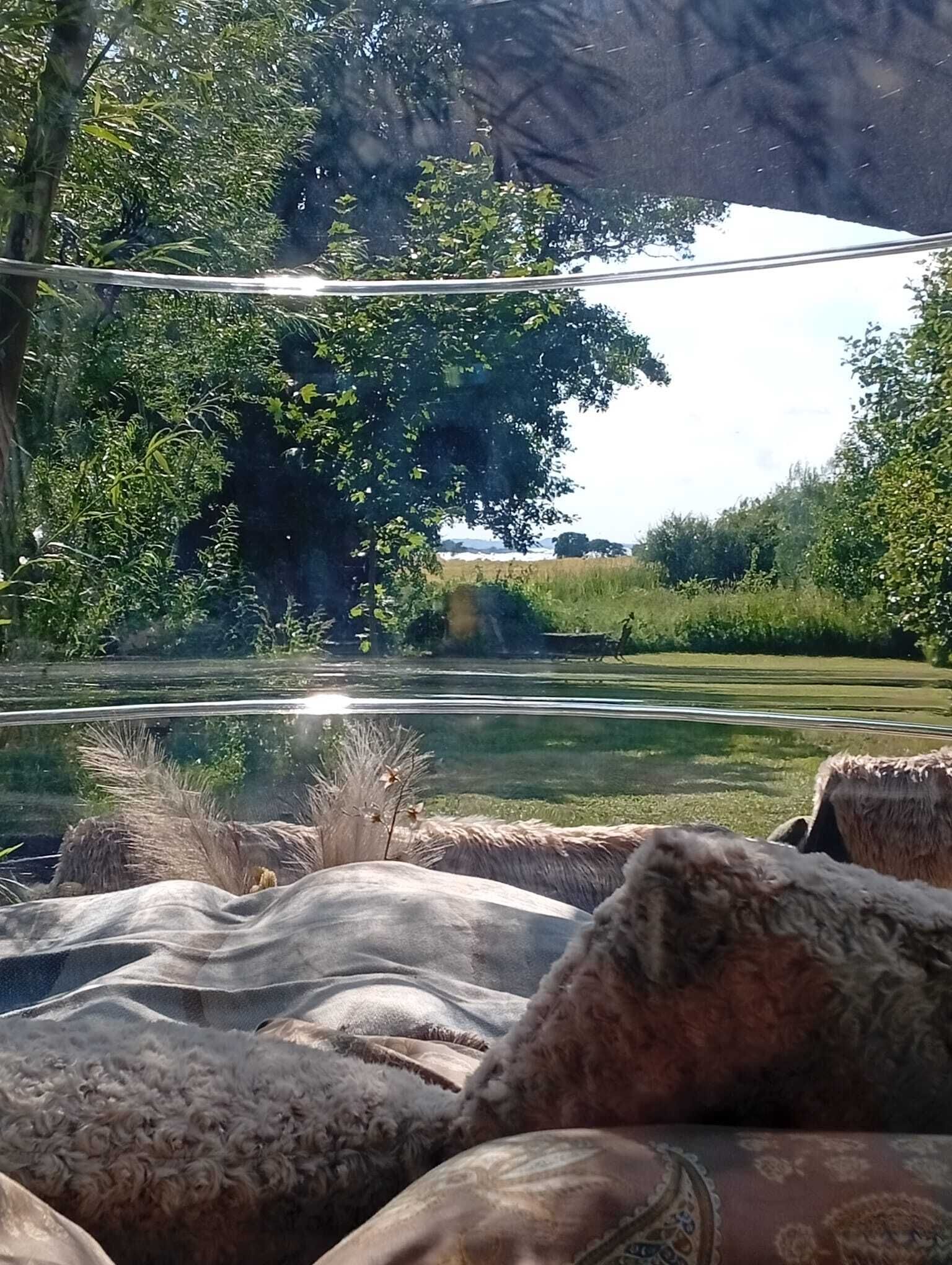 Een rivier met een brug, omringd door groen en bomen.