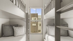 A compact room with bunk beds, a window, and a view of buildings outside. - Beso Del Sol 4 Bedroom Townhouse (St. George)