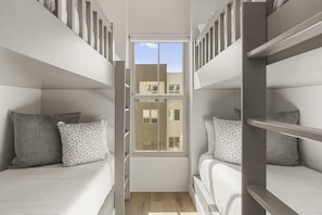 A compact room with bunk beds, a window, and a view of buildings outside. - Beso Del Sol 4 Bedroom Townhouse (St. George)