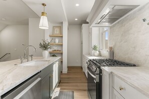 A modern kitchen with a central island, stainless steel appliances, and a pendant light. - Beso Del Sol 4 Bedroom Townhouse (St. George)