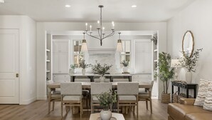 A modern kitchen with white cabinetry, a central island, and pendant lighting. - Beso Del Sol 4 Bedroom Townhouse (St. George)