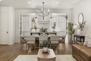 A modern kitchen with white cabinetry, a central island, and pendant lighting. - Beso Del Sol 4 Bedroom Townhouse (St. George)