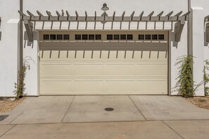 A garage door with a white exterior and a wooden pergola above it. - Beso Del Sol 4 Bedroom Townhouse (St. George)