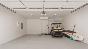 A garage with a golf cart, a paddleboard, and a ceiling-mounted projector. - Beso Del Sol 4 Bedroom Townhouse (St. George)