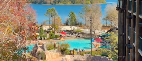 Un complexe hôtelier doté d’une piscine, d’une cascade et offrant une vue sur un lac.
