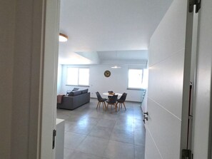 Ein modernes Interieur mit Essbereich, einer Couch und einer Uhr an der Wand.