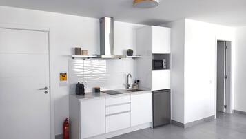 Cafetera o tetera, frigorífico, microondas y placa de cocina