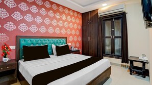 A hotel room with a bed, a nightstand, a dresser, a wardrobe, and an air conditioning unit. - Hotel O IGI Airport Mahipalpur (New Delhi)