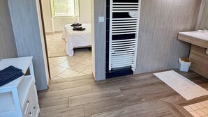 Ein modernes Badezimmer mit einem weißen Waschbecken, einem Spiegel und einem Handtuchhalter.