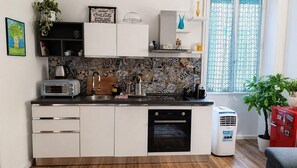 A modern kitchen with a microwave, toaster, sink, and dishwasher. There is a decorative backsplash and a window with a view. - "Verdastro" Apartment with Wi-Fi and Air Conditioning Near Vatican (Rome)