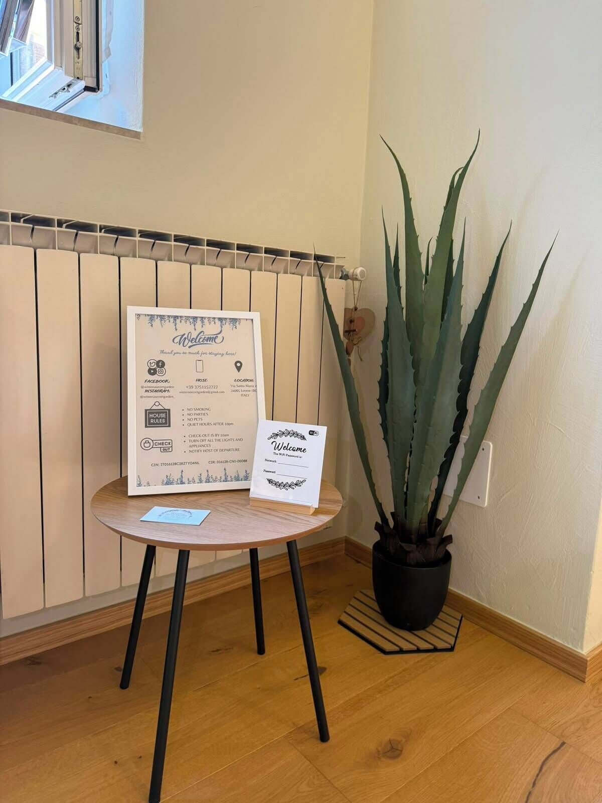 Une pancarte d’accueil indiquant les règles de la maison, ainsi qu’un agave en pot.