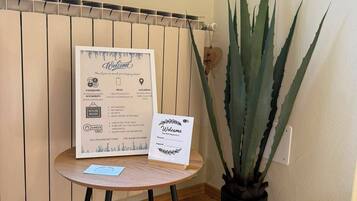 Une pancarte d’accueil indiquant les règles de la maison, ainsi qu’un agave en pot.