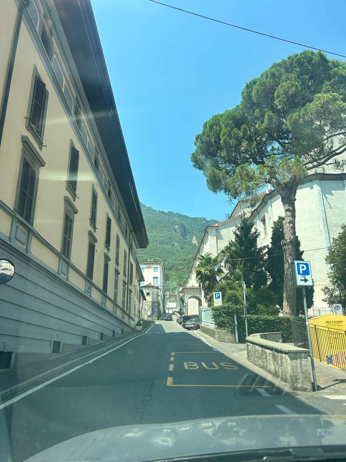 A street with buildings, a bus lane, and a parking sign.