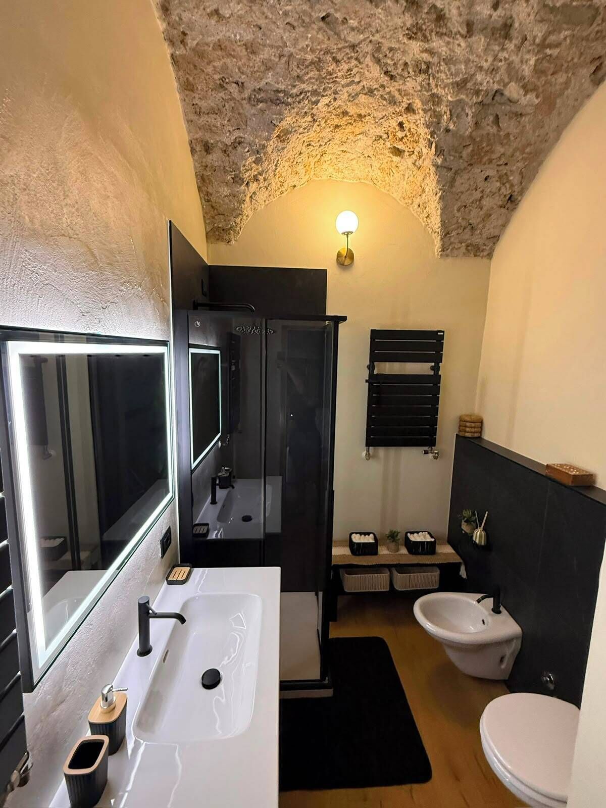 Ein modernes Badezimmer mit großem Spiegel, Waschbecken, Duschbecken und Dusche.