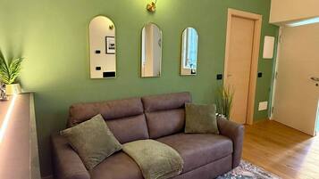 Ein Wohnzimmer mit braunem Sofa, einem gemusterten Teppich und drei Wandspiegeln.