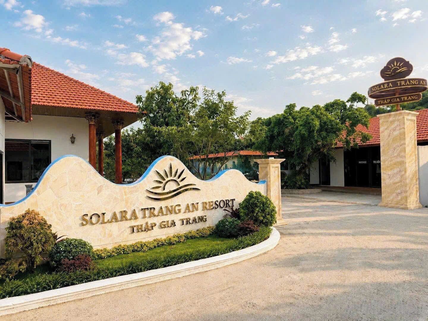 A resort entrance with a sign indicating 'Solara Trang An Resort Thap Gia Trang'.