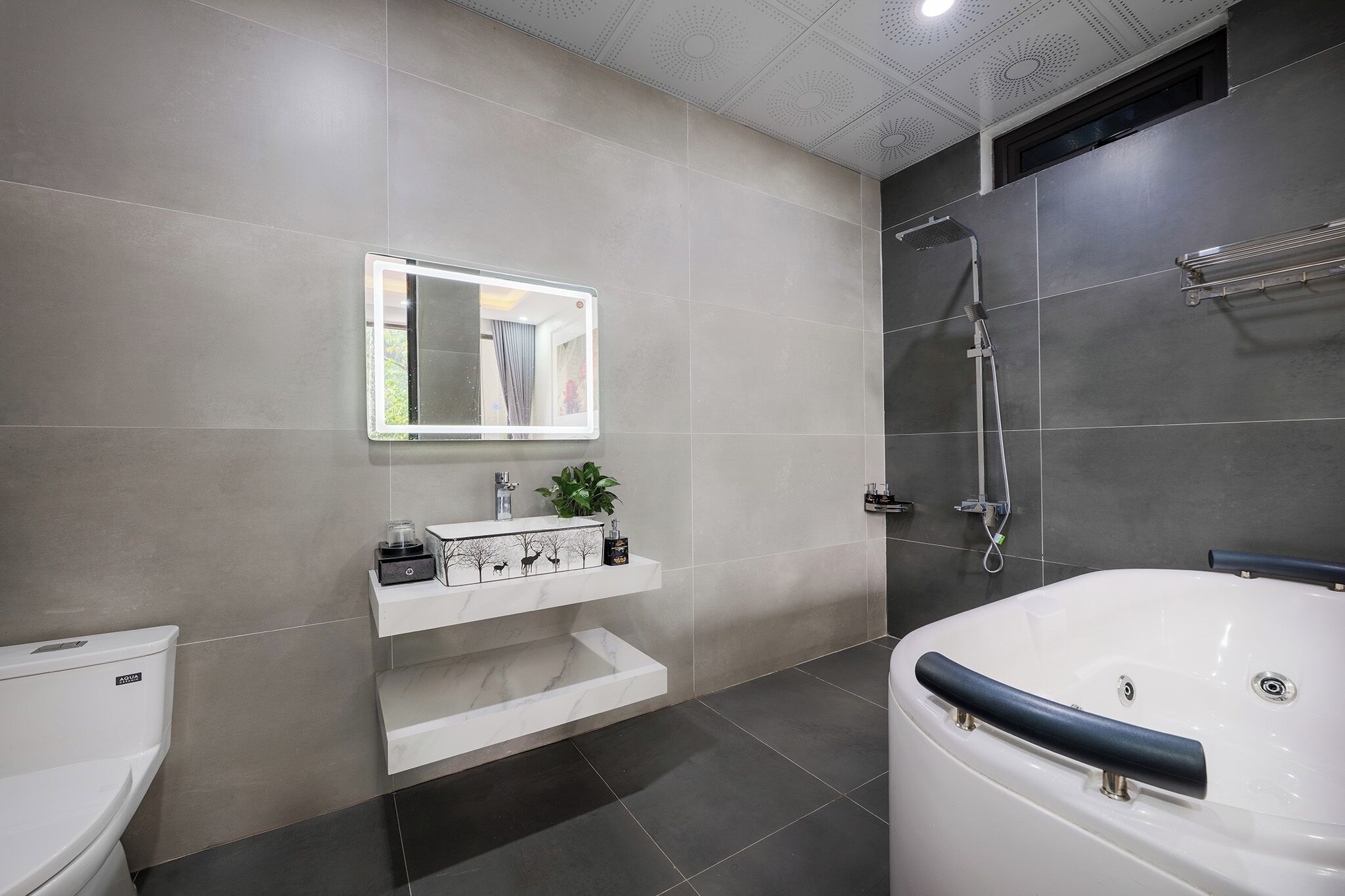 Een moderne badkamer met toilet, wastafel en bad.